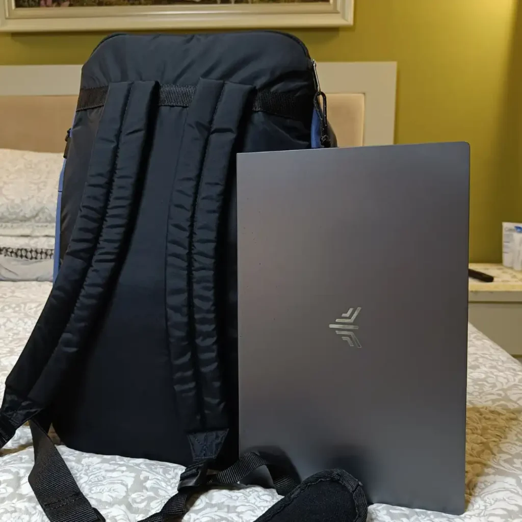 Eastpak Carry Pack backpack shown next to a 15.6 inch laptop to show size compatibility
